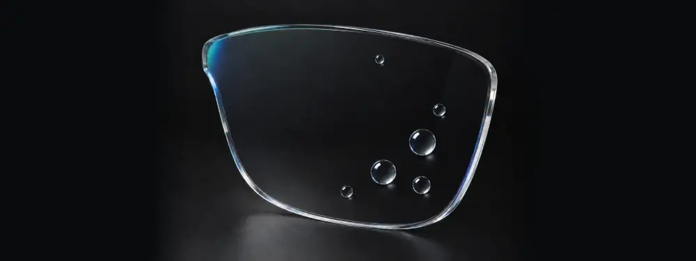 Lente transparente com antirreflexo e gotas de água esféricas sobre o tratamento hidrofóbico